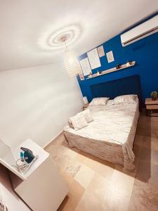 a bedroom with a bed and a blue wall at Charmant duplex proche mer à Carthage in Carthage