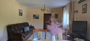 a living room with a leather couch and a table at SUNLUX Seaview Apartment in Đenovići