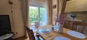 a kitchen with a table with a vase of flowers on it at SUNLUX Seaview Apartment in Đenovići +10 photos