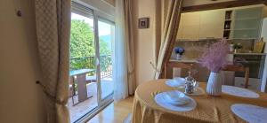 a dining room with a table and a large window at SUNLUX Seaview Apartment in Đenovići