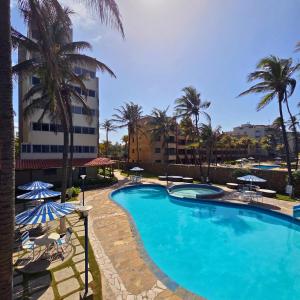 a swimming pool with palm trees and a building at Tucacas, Frente al Mar, Piscina y Playa Privada in Tucacas