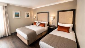 a hotel room with two beds and a window at Westlodge Hotel & Leisure Centre in Bantry +14 photos
