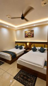 two beds in a hotel room with at Hotel Shakuntla Palace - 400 Meters away from Vishnu Pad Temple 7 mins walk in Gaya