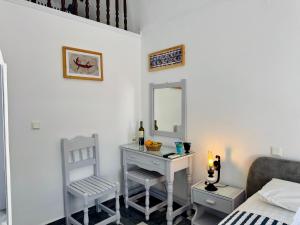 a bedroom with a dressing table and a mirror at Tritonas Rooms in Kamari