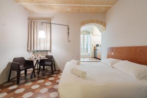 a bedroom with a bed and a table with chairs at La Casa di Nadì in Matera