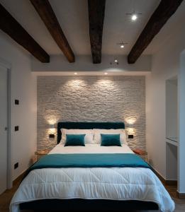 a bedroom with a large bed with a brick wall at Sofi' Center Rooms in Sciacca +100 photos