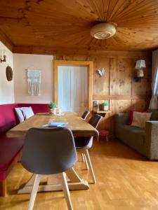 a living room with a table and a couch at Villa Zeppelin - App Aquamarin in Bramberg am Wildkogel