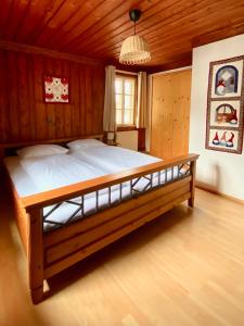 a large bed in a room with a wooden ceiling at Villa Zeppelin - App Aquamarin in Bramberg am Wildkogel