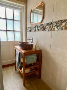 a bathroom with a sink and a mirror on a table at Villa Zeppelin - App Aquamarin in Bramberg am Wildkogel +15 photos