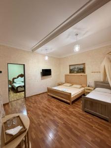 a large room with two beds and a tv at Nugo Villa in Kutaisi