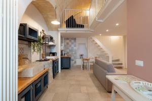 a kitchen and living room with a couch and a table at POZZO FIORITO in Matera