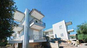 a white building with balconies on the side of it at Areti & Maria Apartments in Gythio
