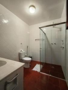 a bathroom with a toilet and a glass shower at Pousada Alecrim Dourado in Paraty