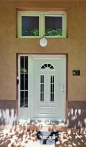 a white door on a house with two windows at G - Apartments in Kumanovo