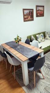 a dining room table with chairs and a couch at G - Apartments in Kumanovo +13 photos