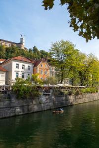 a small boat in a river next to buildings at Vander Urbani Resort - a Member of Design Hotels in Ljubljana