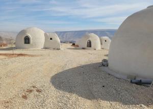 a group of white domed buildings in the desert at Tootya camp in Al Mathlūthah