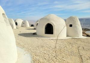a row ofolithic domes in the desert at Tootya camp in Al Mathlūthah