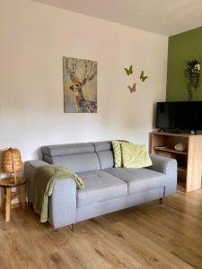 a living room with a couch and a tv at Villa Zeppelin - App Bergkristall in Bramberg am Wildkogel