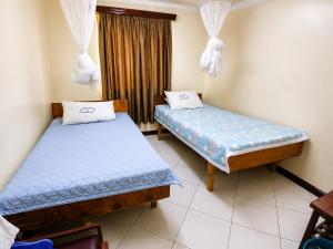two beds in a room with a window at New Swanga in Nairobi