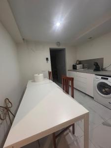 a kitchen with a white table and a washing machine at Casa El Viso in Madrid