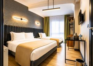 a hotel room with two beds and a television at Nora Airport Hotel in Arnavutköy