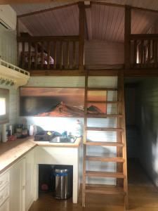 a loft bed in a kitchen with a sink and a ladder at Chaloupka Bečov in Blatno +4 photos