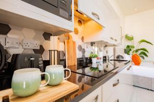 a kitchen with two coffee mugs on a counter at Dublin Central Suites in Dublin