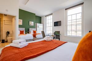 a bedroom with a large bed with towels on it at Dublin Central Suites in Dublin