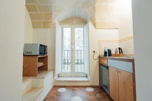 a kitchen with a door to a balcony with a microwave at La Casa di Nadì in Matera