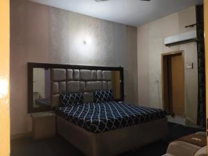 a bedroom with a bed and a large mirror at Lasani view Guest House in Lahore +6 photos