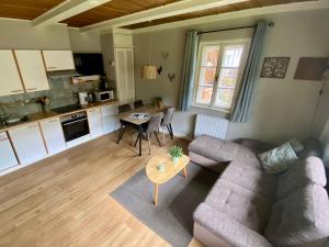 a living room with a couch and a table at Villa Zeppelin - App Smaragd in Bramberg am Wildkogel