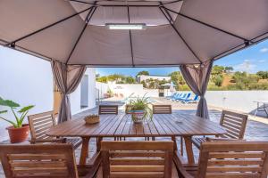 a wooden table and chairs under a large umbrella at Casa Mari in Almogía