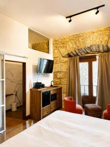a hotel room with a bed and a television at Apartamentos El Capitan in Potes