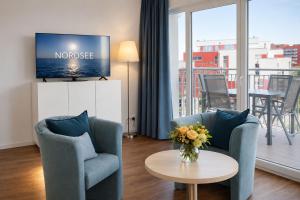 a living room with two chairs and a table with a tv at Vogelkieker in Schillig