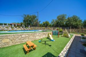 a backyard with a swimming pool and a picnic table and a picnic table at Fisi & Wellness Exclusive Villa with Spa Vibes in Stavromenos