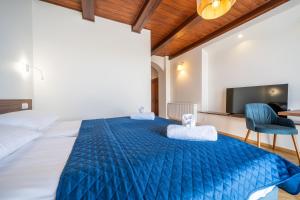 a bedroom with a large blue bed and a tv at Pensjonat Mikołajki in Mikołajki