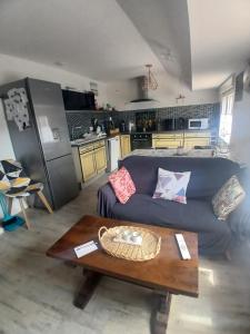 a living room with a blue couch and a table at Petit bien in Marcillac