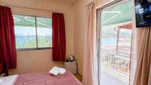 a bedroom with a bed and a large window at Avli Studios in Nydri