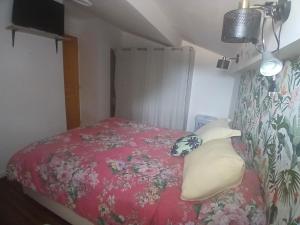 a small bedroom with a bed with a red bedspread at Petit bien in Marcillac