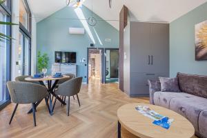 a living room with a couch and a table at Elite House Platina Apartment in Leányfalu