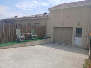 a patio with two chairs and a table on a fence at Petit bien in Marcillac