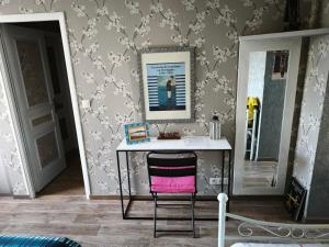 a desk with a pink chair in a room at Ty Capitaine Chambres d'hôtes Guidel in Guidel