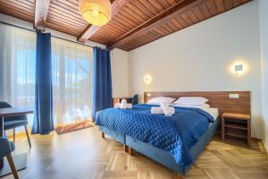a bedroom with a bed with a blue comforter at Pensjonat Mikołajki in Mikołajki