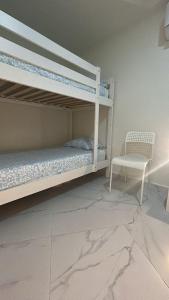 a bedroom with two bunk beds and a chair at SIMPL hostel Oquendo in Madrid