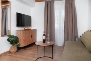 a living room with a bottle of wine on a table at Aurelia Boutique - Suites in Rhodes Town