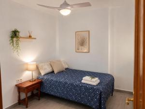 a bedroom with a bed and a table with a lamp at COSTA DE ALMERIA PLAYA in Almería