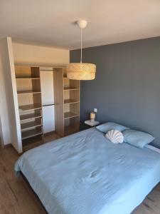 a bedroom with a blue bed and a light blue wall at Les embruns du retz in Chaumes en Retz