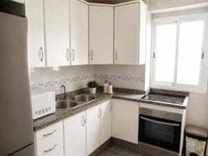 a kitchen with white cabinets and a sink at COSTA DE ALMERIA PLAYA in Almería
