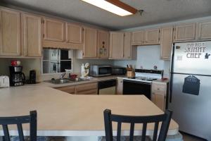 a kitchen with wooden cabinets and a white refrigerator at River Place Condos #410 3BD in Pigeon Forge +14 photos
